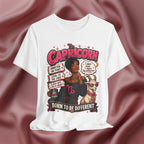 White t-shirt with Capricorn zodiac design featuring a woman and goat on a maroon fabric background.