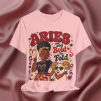 Pink T-shirt with Aries zodiac design featuring a woman and ram on a maroon fabric background