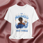 White t-shirt with Aquarius design featuring a black woman and text 'The original free thinker' on a pink fabric background