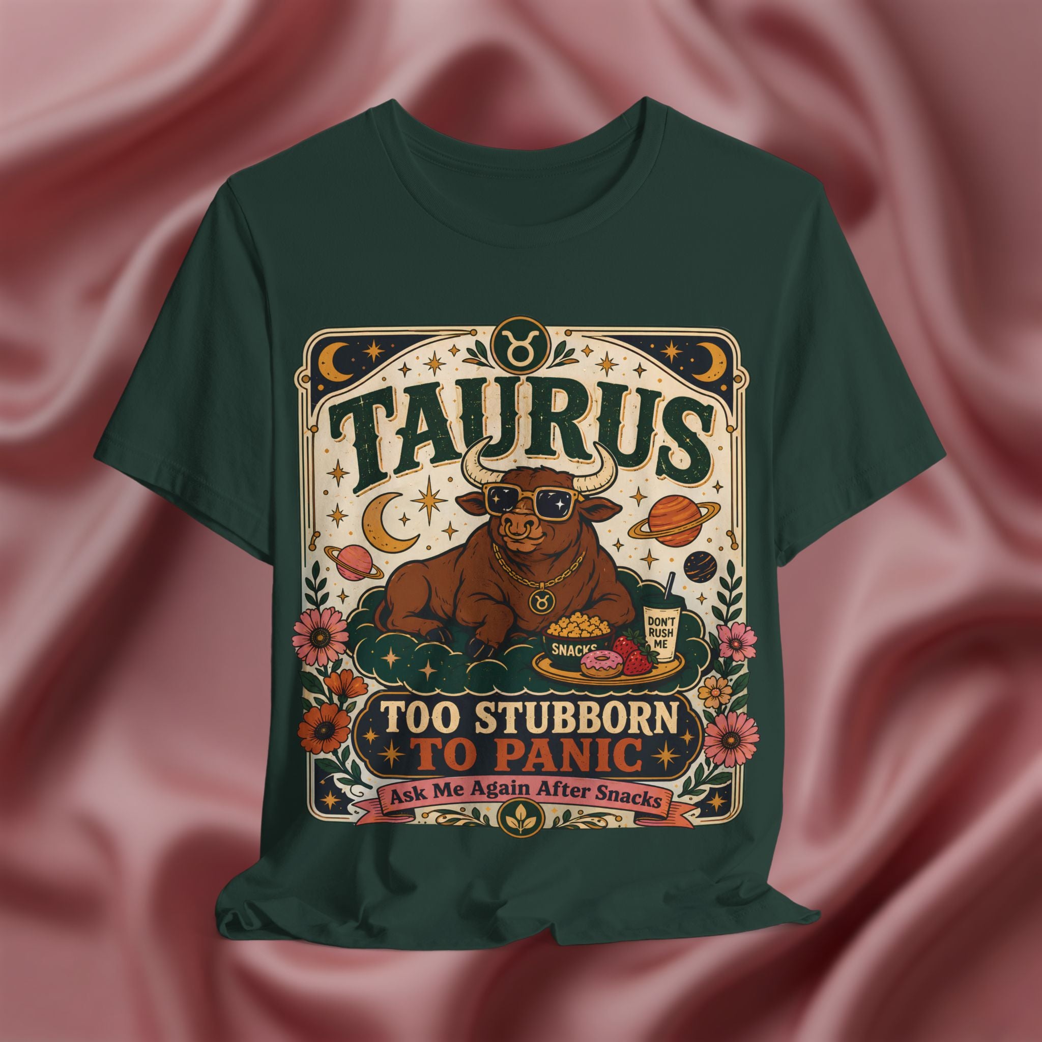 Green t-shirt with Taurus zodiac design on a pink fabric background