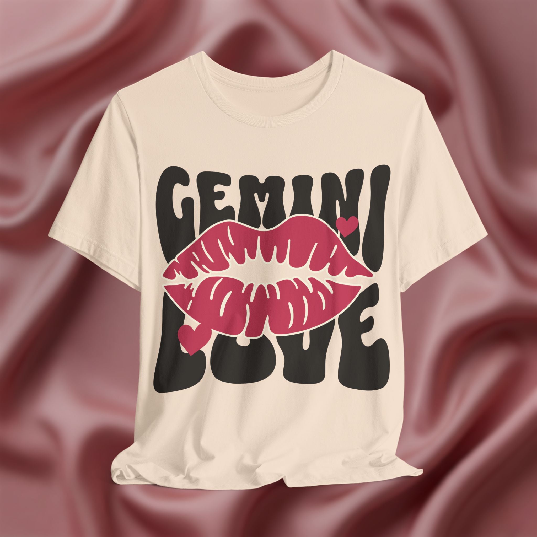 Soft cream t-shirt with 'GEMINI LOVE' design on a maroon fabric background