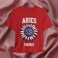 Red t-shirt with American flag sunflower and 'ARIES ENERGY' text on a textured pink background