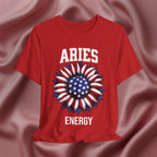 Red t-shirt with American flag sunflower and 'ARIES ENERGY' text on a textured pink background