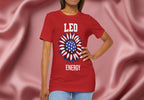 Person wearing a red t-shirt with American flag sunflower and 'LEO ENERGY' text on a textured pink background