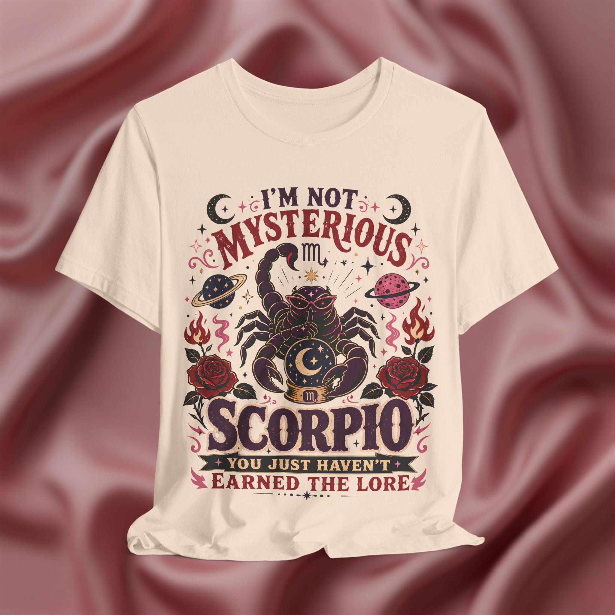soft cream t-shirt with Scorpio design and text on a maroon fabric background