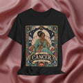 Black t-shirt with Cancer zodiac design on a pink fabric background