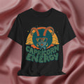 Black t-shirt with Capricorn design and 'Capricorn Energy' text on a pink fabric background