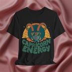 Black t-shirt with Capricorn design and 'Capricorn Energy' text on a pink fabric background
